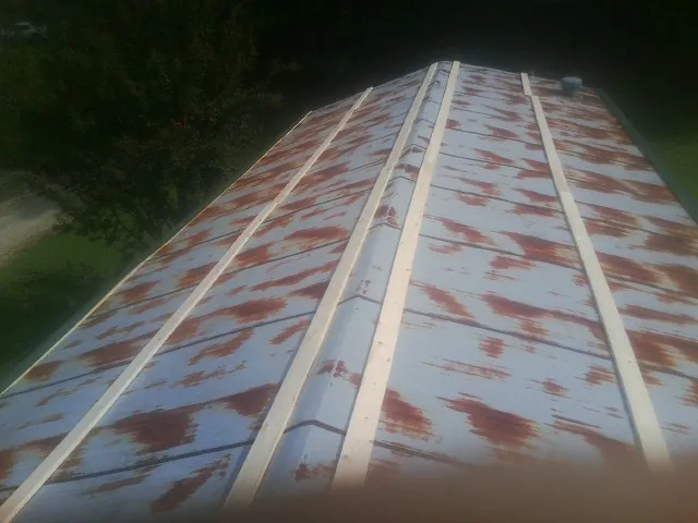Rusted metal roof panels with new wood purlins before replacement — Storm Damage Roof Repair in Coldwater by Roofing Brothers